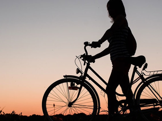 woman on bike with sunset