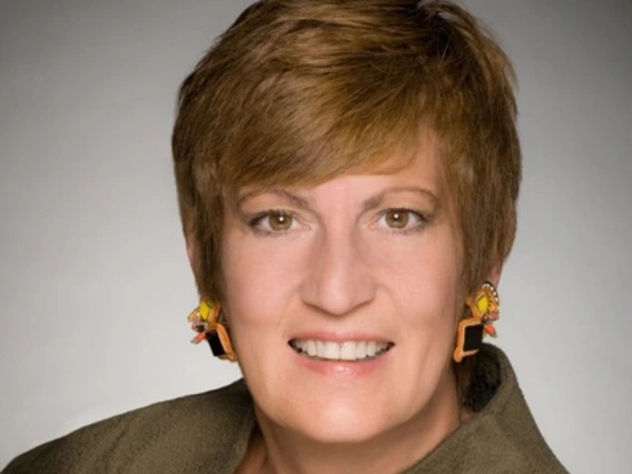 A headshot of a woman with short hair in a green shirt 