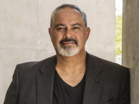 A photo of a man wearing a dark shirt and a dark blazer