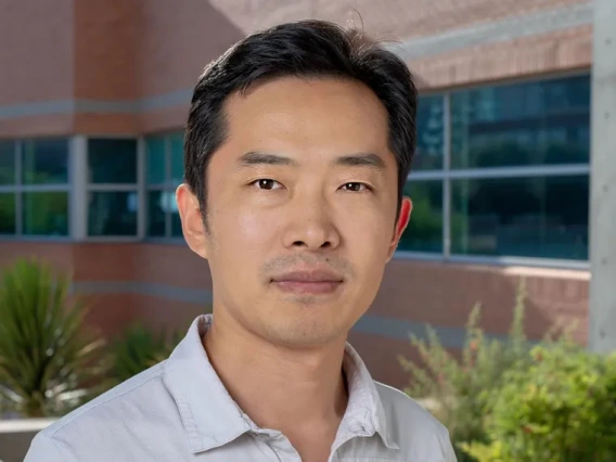 A photo of a man in a white shirt in front of a building