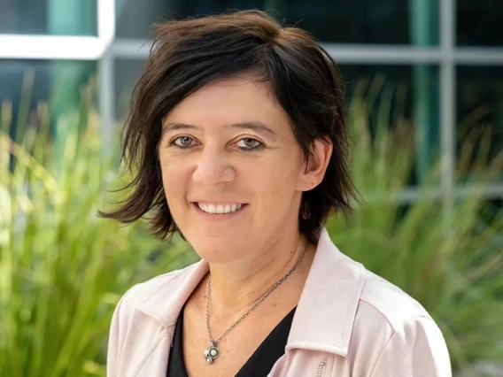 A photo of a woman with short dark hair wearing a white shirt