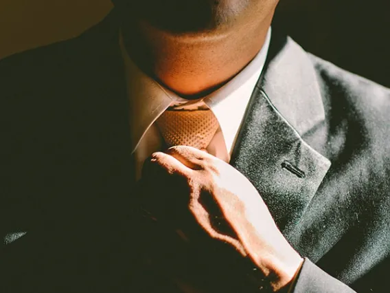 man adjusting necktie