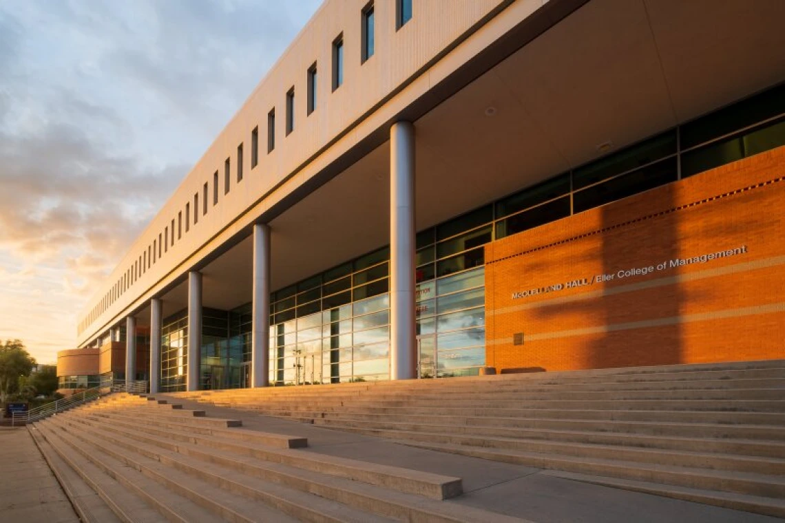 A photo of Eller College of Management with the sunset behind it