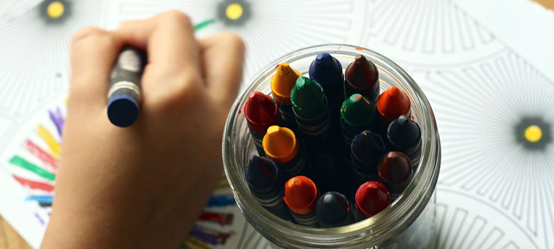 child's hand with crayons