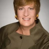 A headshot of a woman with short hair in a green shirt 