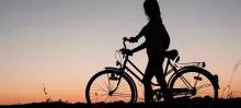 woman on bike with sunset