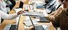 people holding file at desk